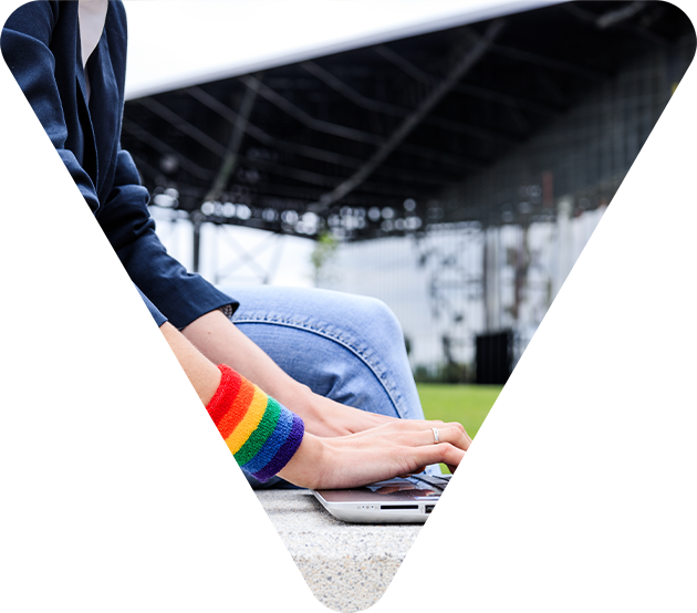 Mensch am Laptop mit Regenbogen Armband